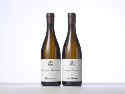 two bottles of wine sitting on top of a table next to each other