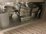 many pans and pans sitting on a shelf in a kitchen