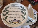 une assiette sur laquelle est posé un poisson, posée sur une table