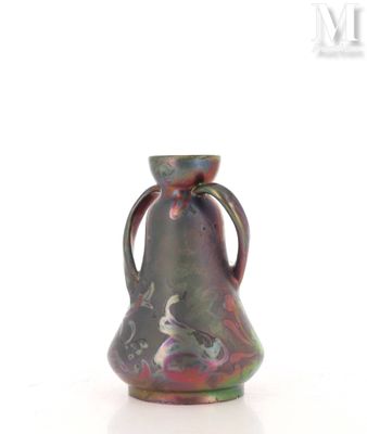 a small vase with a handle on a white surface