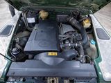 a green car with its hood open and the engine in the trunk
