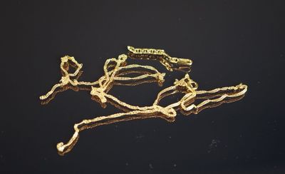 un bracelet en or posé sur une surface noire