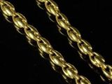 a close up of two gold chains on a black surface