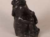 bronze statue of a man and a woman sitting on a rock