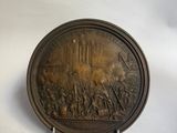 une plaque antique en bronze représentant la bataille de Waterloo sur fond blanc