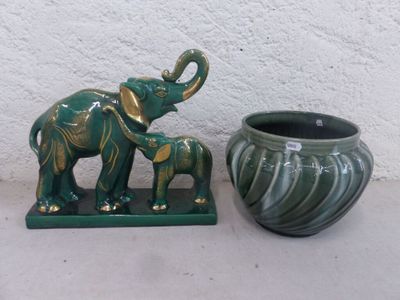 une paire de figurines d'éléphants en céramique verte, à côté d'un vase en céramique verte