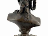 bronze bust of a woman with curly hair on a wooden base
