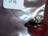 une bague en argent sertie d'un diamant, posée sur une pomme rouge