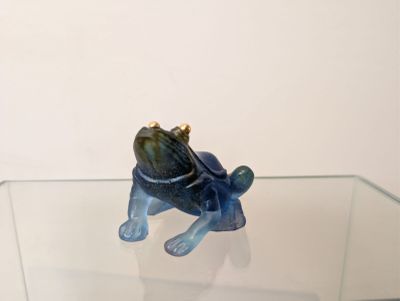 une table en verre sur laquelle se trouve une petite grenouille bleue