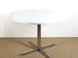 une image représentant une table blanche avec un piètement en croix métallique