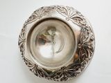 a silver plate on a white table with a silver spoon