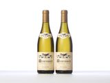 two bottles of white wine sitting on top of a table