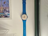 une montre bleue accrochée au mur près d'une fenêtre