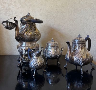 three silver teapots sitting on a table next to each other