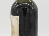a black bottle with a red top and a label on it