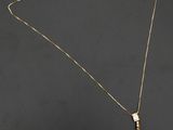un collier en or auquel sont suspendues trois perles