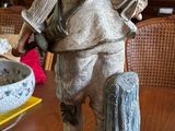 a statue of a man with a hat and a bag on a table
