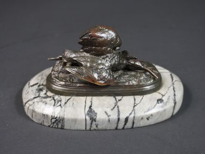 statue d'un garçon assis sur un socle de marbre, tenant un oiseau dans la main
