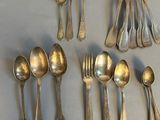 a lot of silver spoons and silverware on the table