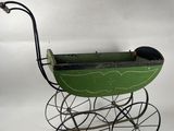 a green baby stroller with a black handlebar