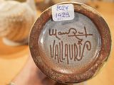 a brown vase with writing on it sitting on a table