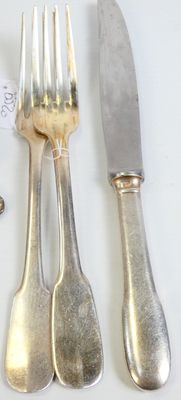 a lot of silverware on a table with a knife and fork