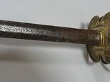 a close up of a sword on a white surface