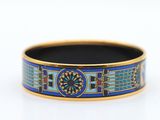 a close up of a blue and gold bracelet on a white surface