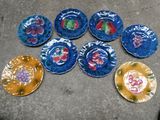 six assiettes ornées de motifs différents, posées par terre