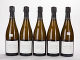 quatre bouteilles de vin sont alignées sur une surface blanche