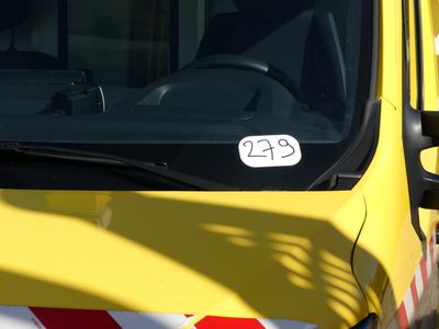 un camion jaune orné d'une bande rouge et blanche