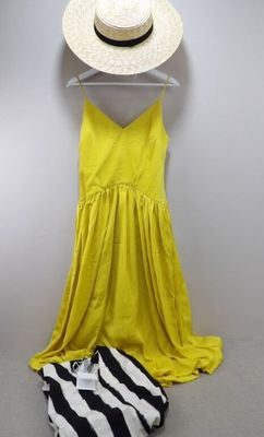 une robe jaune et un chapeau suspendus à un cintre à côté d'un sac à imprimé zébré