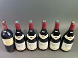 six bottles of wine are lined up in a row on a table