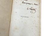 an old book with writing on it sitting open on a white surface