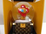 a snow globe in a box with a teddy bear inside of it