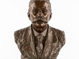 un buste en bronze représentant un homme en costume-cravate
