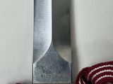 a knife that is tied to a red and white rope