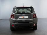 the back end of a grey car in a room with a white wall