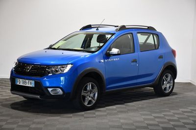 une Dacia bleue garée dans une pièce au sol carrelé
