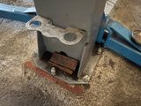 a machine that is sitting on the ground next to a piece of wood