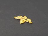 a close up of a piece of gold on a black surface