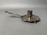 a silver plate with a spoon on it on a table