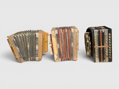 two old accordions sitting side by side on a white surface