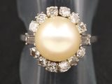 un gros plan d'une bague ornée d'une perle et de diamants