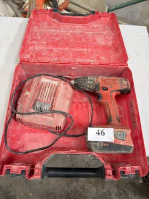 une boîte à outils rouge contenant une perceuse et un marteau
