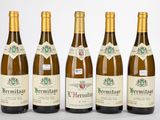 six bouteilles de vin sont alignées sur une surface blanche