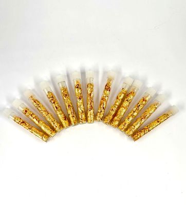 a close up of a bunch of gold glitter sticks on a white surface