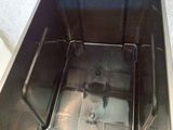 a metal container with a lid open on the floor