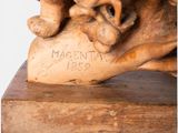 statue of a dog with a bone in its mouth on a wooden base