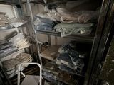 a room filled with lots of clothes and a chair